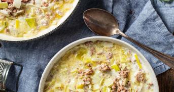 Käse-Lauch-Suppe in einer Schüssel und einem Topf mit angelegtem Löffel.