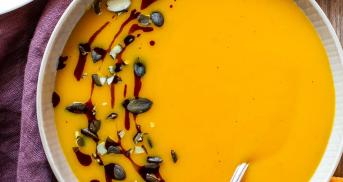 Kürbissuppe mit Kartoffeln, Balsamico und Kernen in einer Suppenschale.