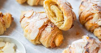 Marzipan Croissants auf einem Backblech, bestäubt mit Puderzucker