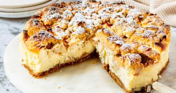 Apple Crumble Cheesecake angeschnitten auf einer Kuchenplatte