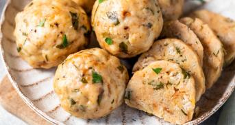 Dampfgegarte Semmelknödel in einem tiefen, gewellten Teller mit Petersilie auf einem Tisch