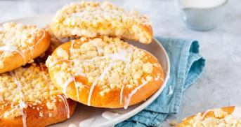 Vier Streuseltaler mit Zuckerguss gestapelt auf einer Kuchenplatte