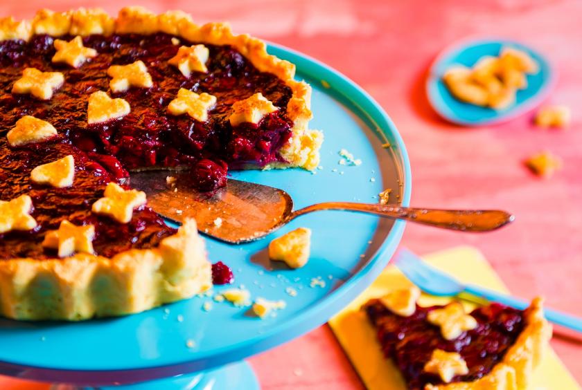 Cherry Pie angeschnitten auf einer Kuchenplatte mit Kuchenheber.