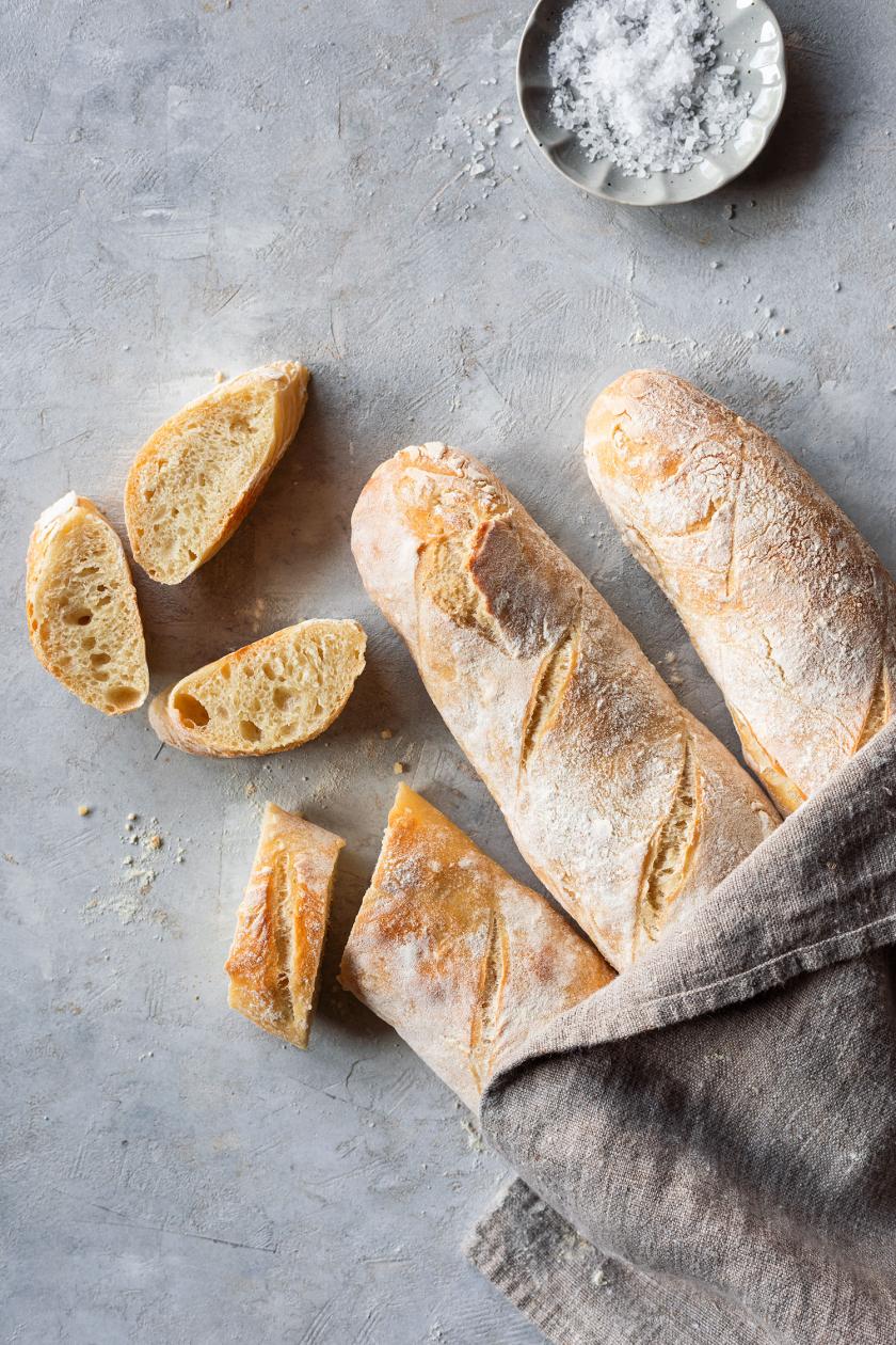 Drei Baguettes, eines davon in Scheiben geschnitten.