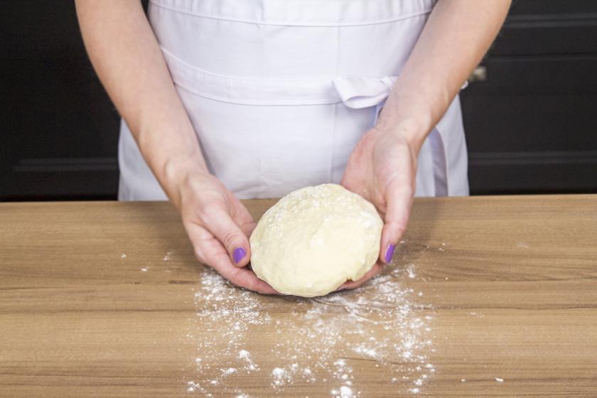 Flammkuchenteig mit Hefe zu einer Kugel geformt.