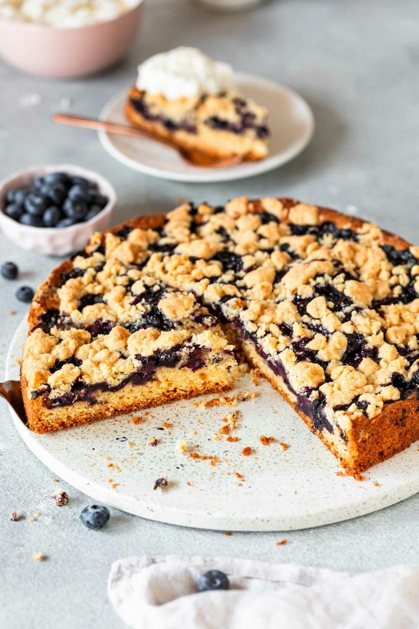 laubeerkuchen mit Streuseln angeschnitten auf einem Kuchenteller