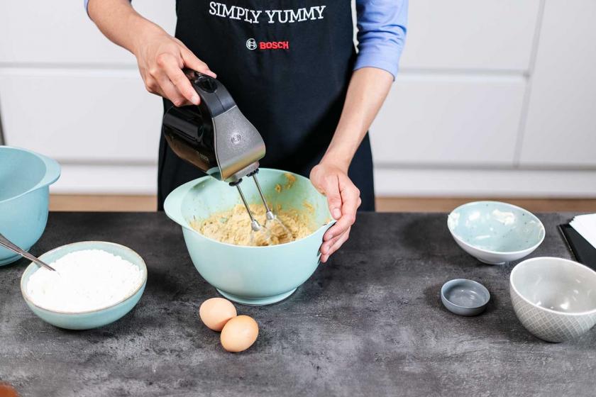 Der teig für die American Cookies wird mit einem Handmixer in einer Rührschüssel verrührt.