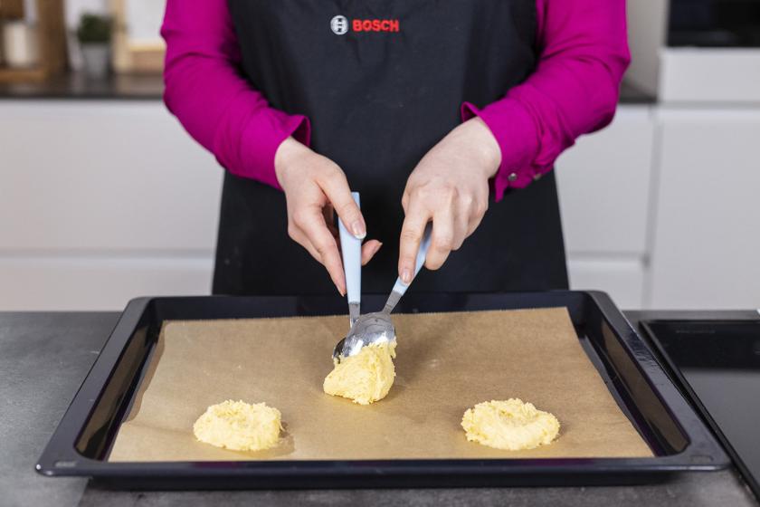 Der Teig für die Amerikaner wird auf ein Blech gegeben.