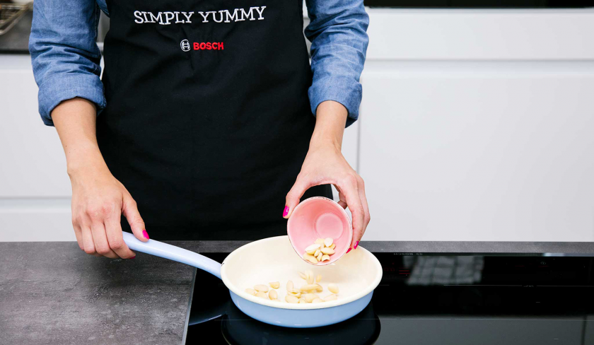 Mandeln für den Apfelkuchen mit Quark werden in eine Pfanne gegeben.