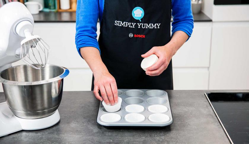 Muffinform wird mit Papierhülsen ausgekleidet.
