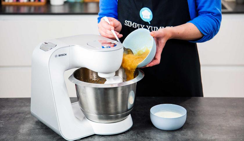 Apfelmus wird in die Rührschüssel einer Küchenmaschine gegeben.
