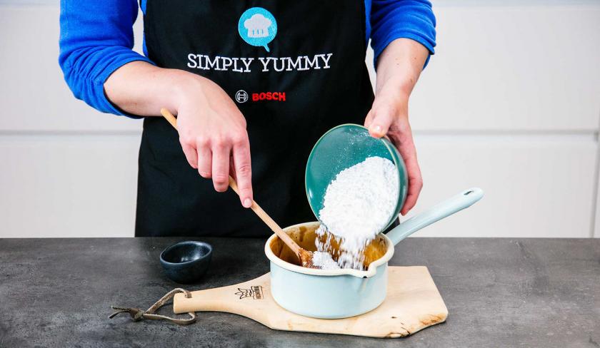 Puderzucker wird in einen Topf gegeben.