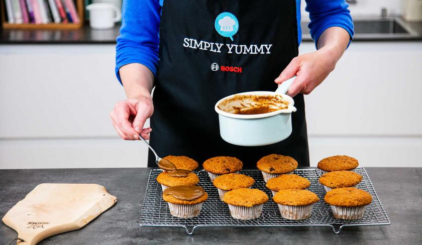 Apfelmusmuffins werden mit Guss bedeckt.