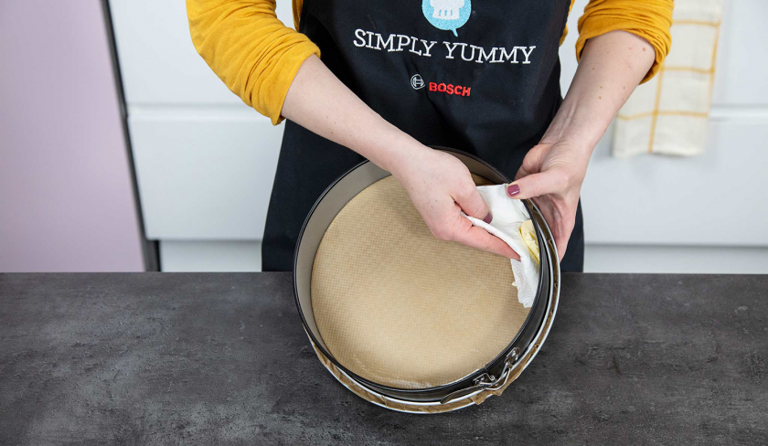 Springform für den Aprikosenkuchen mit Streuseln wird eingefettet.