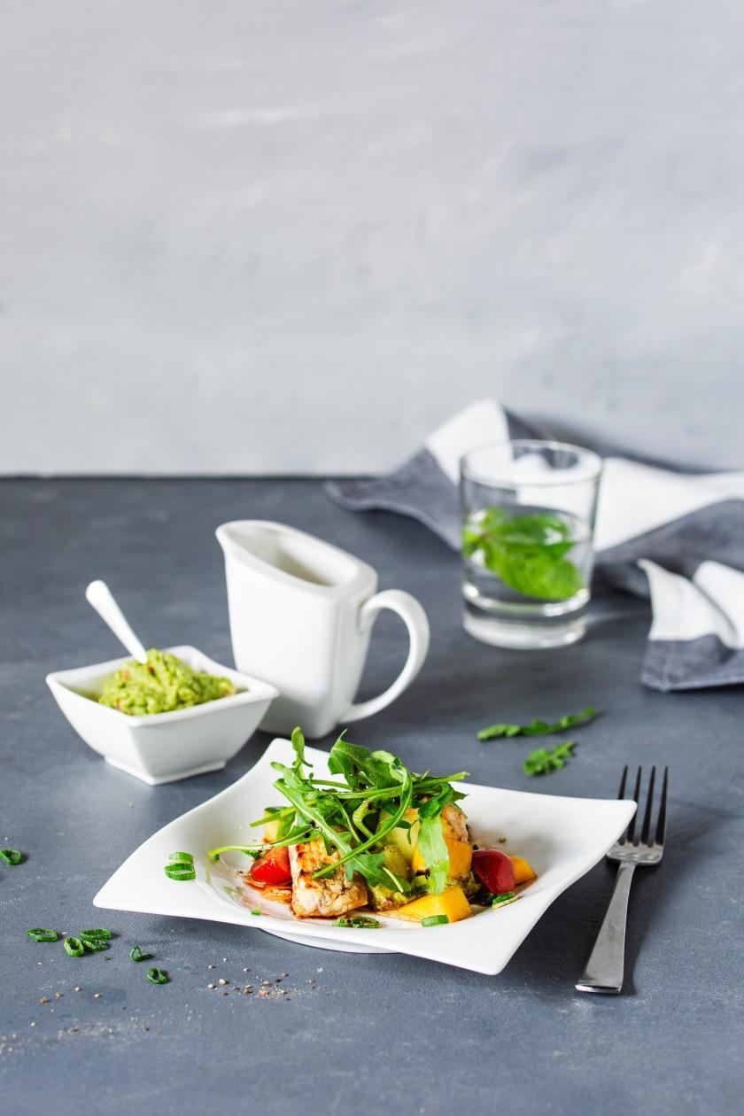 Avocado-Mango-Salat mit Ziegenkäse auf weißem Teller.