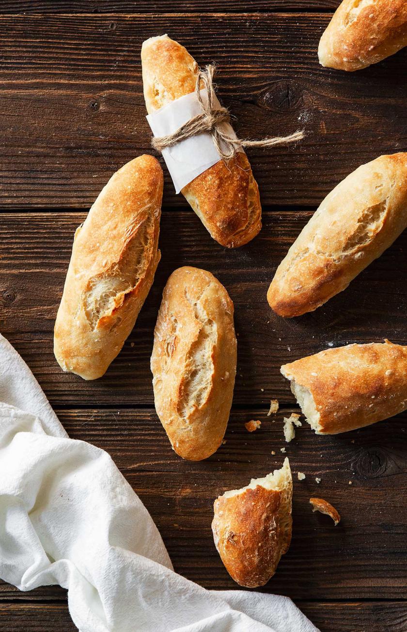Mehrere Baguette Brötchen auf einem Holztisch.