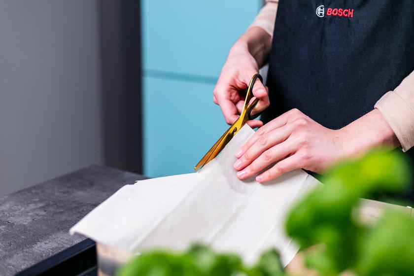 Filoteig wird mit einer Schere zugeschnitten.
