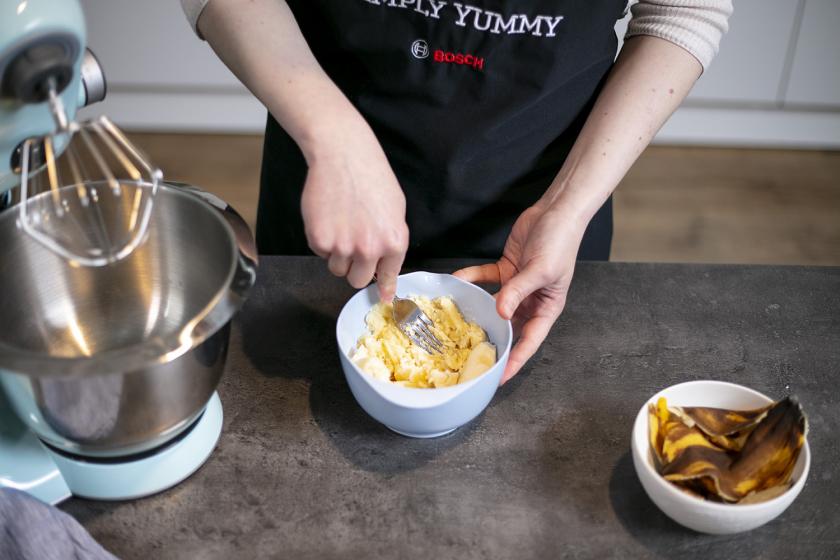 Bananen werden in einer Schüssel mit einer Gabel zerdrückt.
