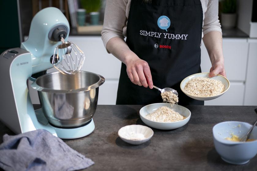Haferflocken werden zu Mehl in eine Schale gegeben und vermischt.