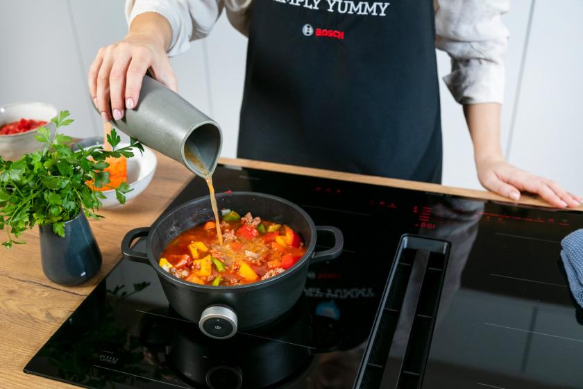 Gemüsebrühe wird zum Bauerntopf in den Topf gegeben.