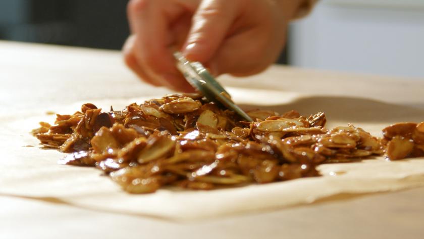 Mandelkrokant wird auf dem Backpapier glatt gestrichen.