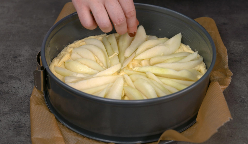 Für den Birnenkuchen mit Knusperkruste wird das Obst auf dem Teig verteilt.