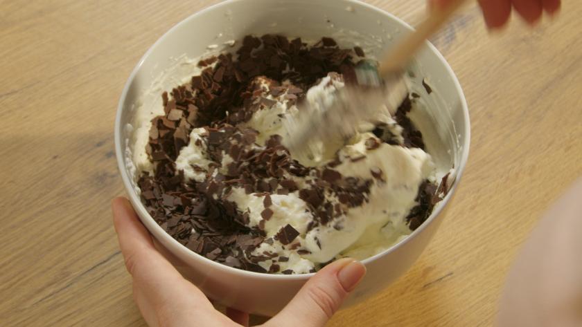 Aufgeschlagene Sahne wird mit Schokoraspeln verrührt.