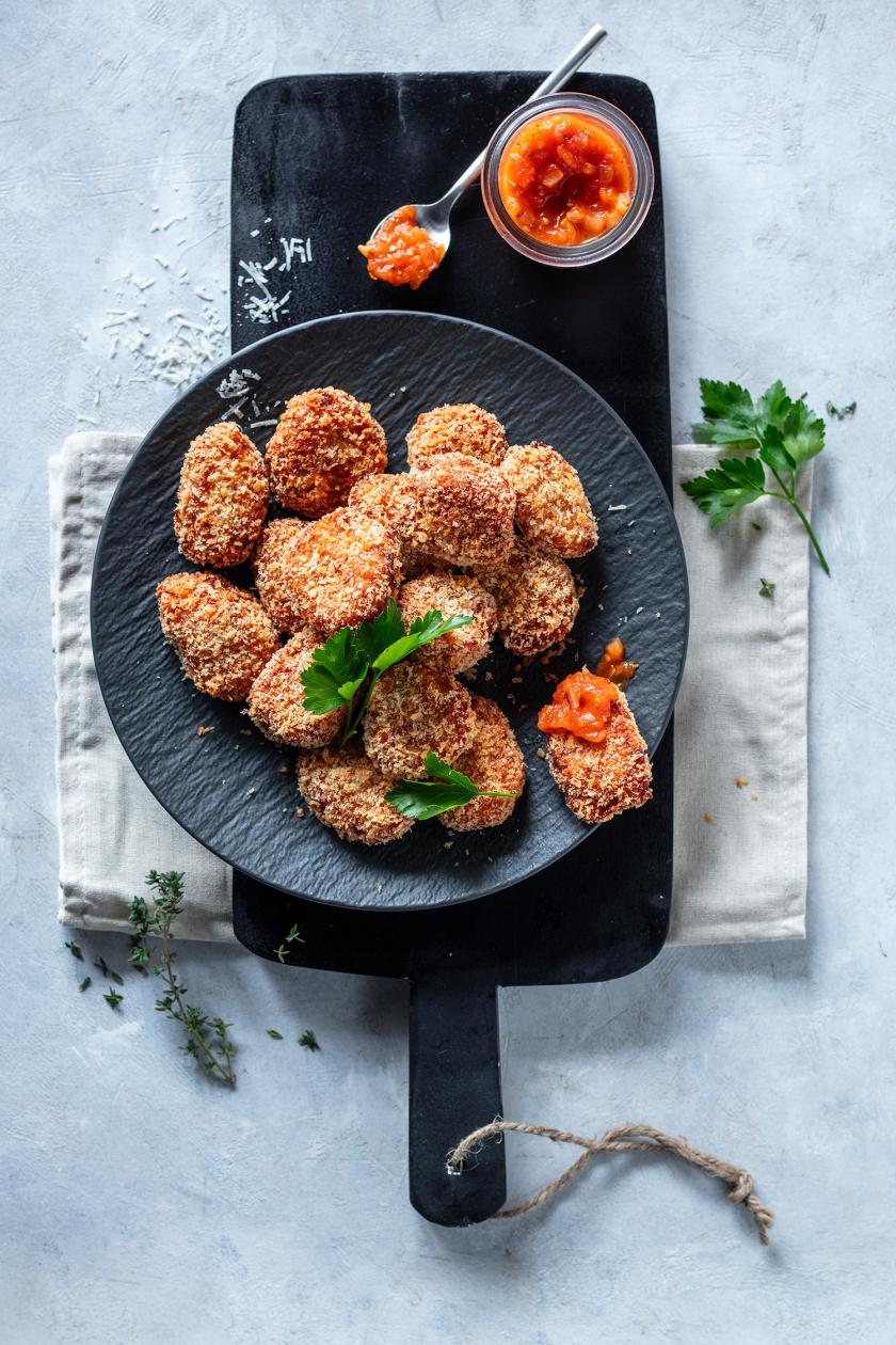 Mehrere Blumenkohl Nuggets mit Chutney auf einem Teller.