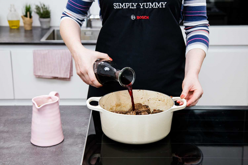 Rotwein wird zum Boeuf Bourguignon in den Bräter gegeben.