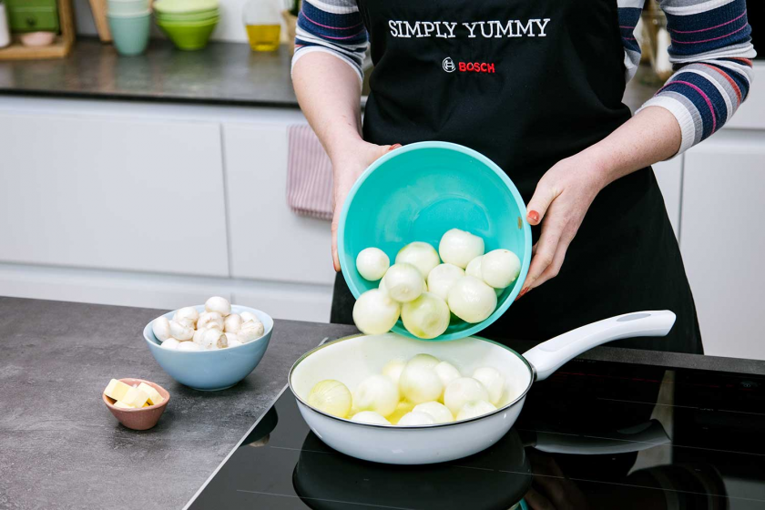 Für die Schmorzwiebeln für Boeuf Bourguignon werden Zwiebeln in eine Pfanne gegeben.