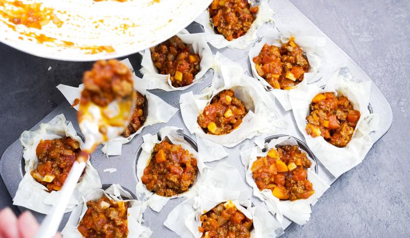 Die Teignester für die Bolognese-Törtchen mit Knusperteig werden befüllt.