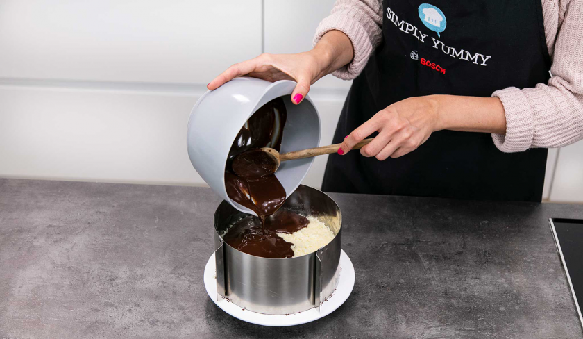 Die Ganache wird auf den Bounty Kuchen gegeben.