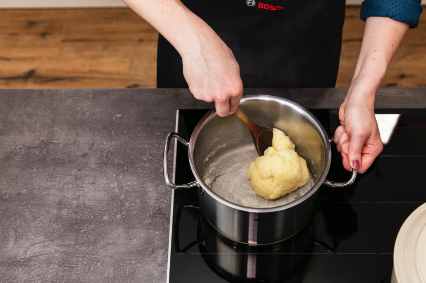 Brandteig wird in einem Topf abgebrannt.