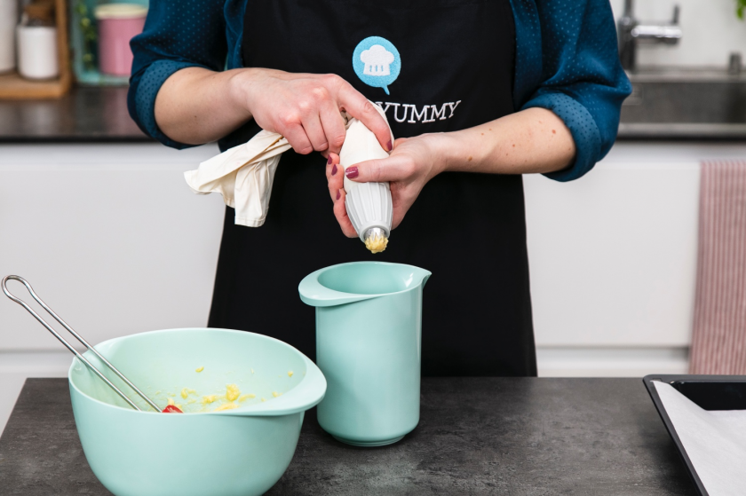 Brandteig wird in eine Spritztüte gefüllt.