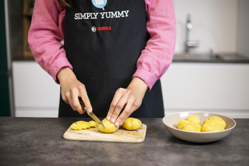 Pellkartoffeln werden in Scheiben geschnitten.