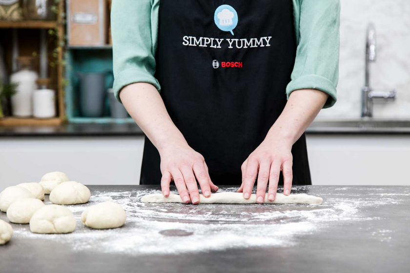 Der teig für die Brezel wird zum Strang gerollt.