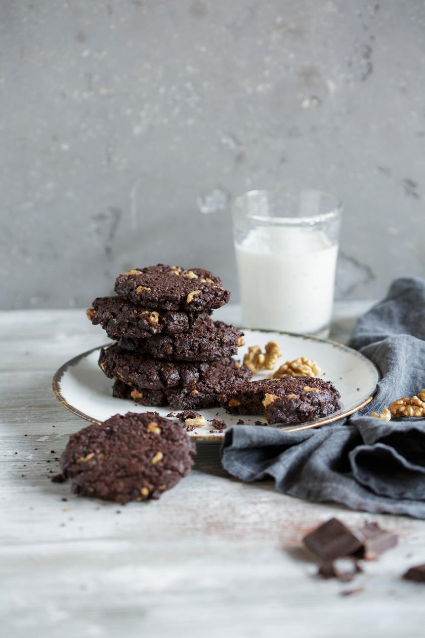 Mehrere Brownie-Cookies auf einem Teller, daneben ein Glas Milch.