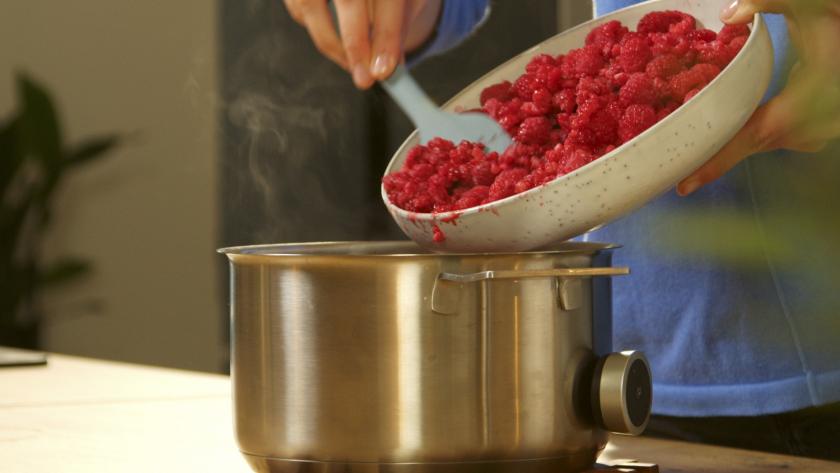 Himbeeren werden in einen Topf gegeben.