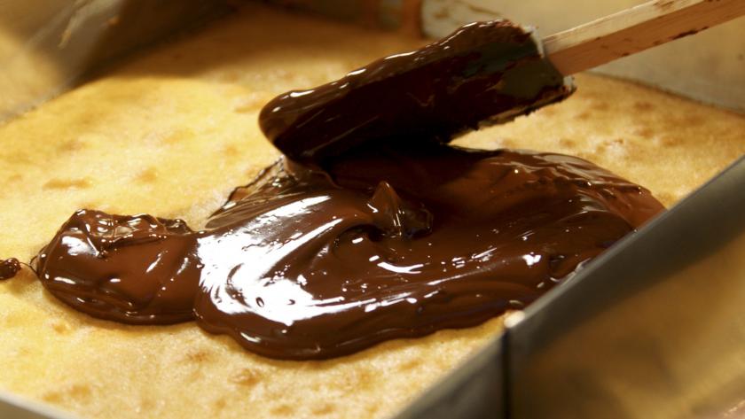 Schokolade wird auf dem Kuchenboden verstrichen.
