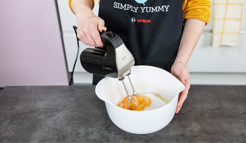 Eier und Zucker werden mit einem Handmixer schaumig geschlagen.