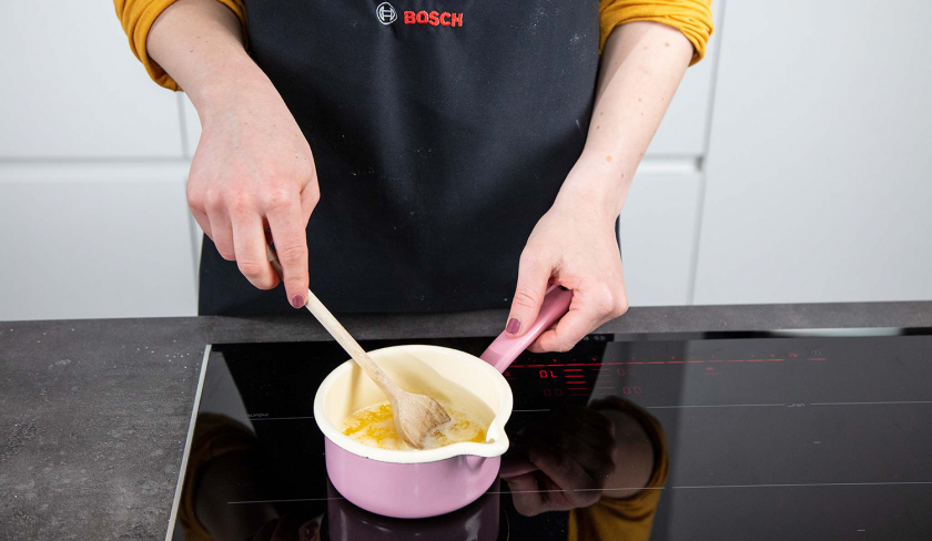 Für eine Tränke für den Buttermilchkuchen wird Butter in einem Topf geschmolzen.