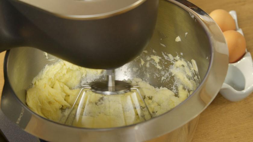 Butter wird mit Zucker in einer Küchenmaschine cremig gerührt.