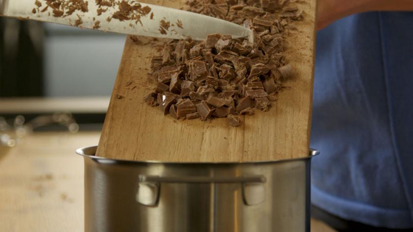 Gehackte Schokolade wird in einen Topf gegeben.