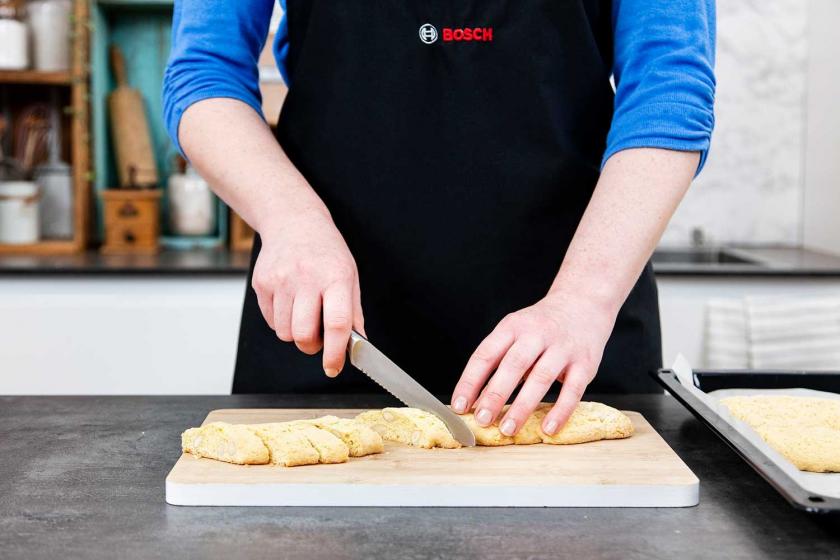 Cantuccini-Teigrolle wird schräg in Scheiben geschnitten.