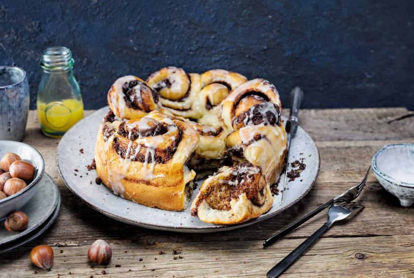 Chocolate-Cinnamon-Rolls-Cake mit Guss auf einem Teller.