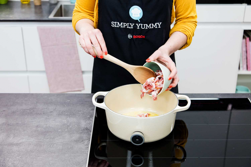 Für das Coq au Vin wird Speck wird in einen Topf.