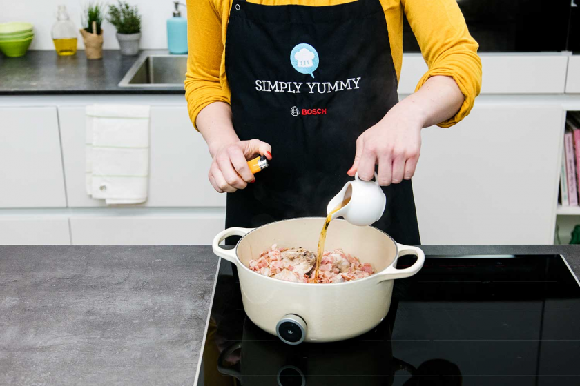 Zum Fleisch für das Coq au Vin wird Cognac gegossen.