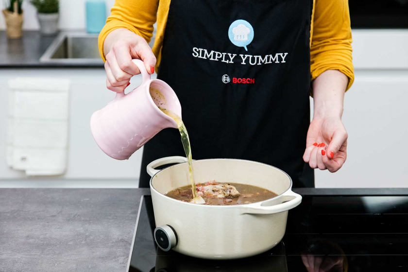 Fond wird zum Coq au Vin gegossen.