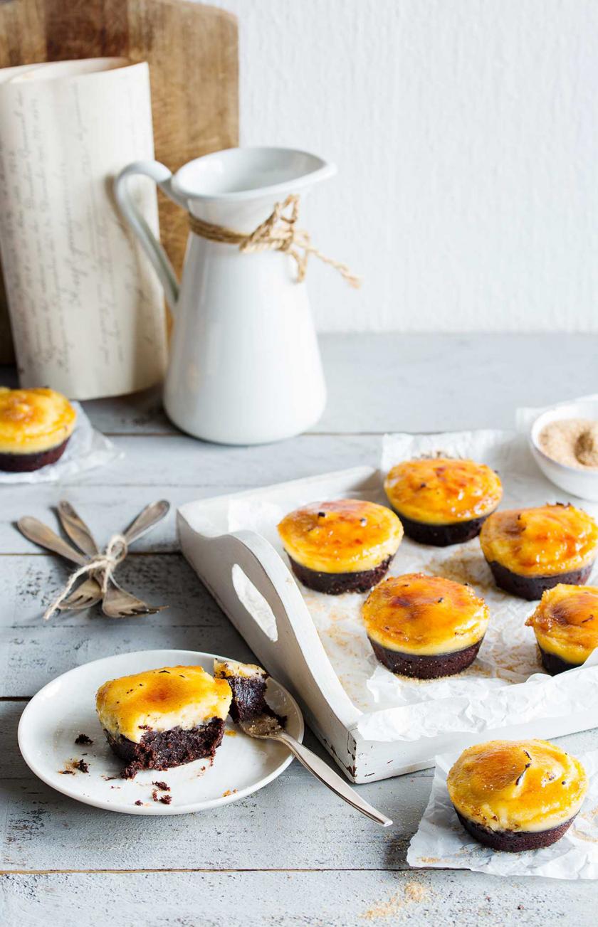 Mehrere Crème Brulée Brownie Törtchen auf einem Tablett. Im Vordergrund eins davon auf einem Teller.
