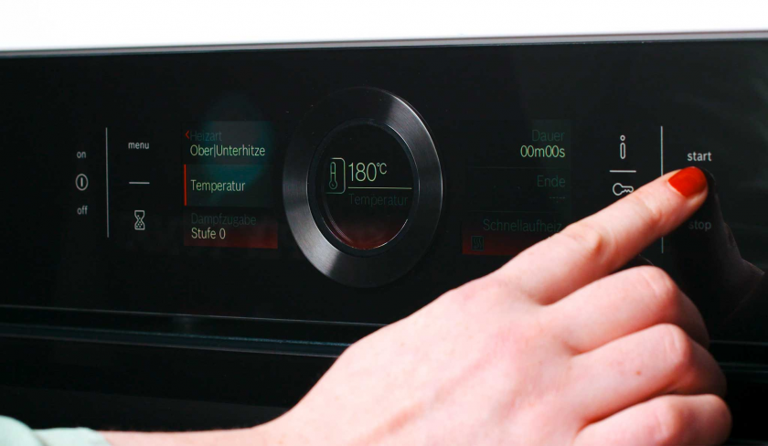 Jemand schaltet den Bakofen für die Crème Brulée Brownie Törtchen an.